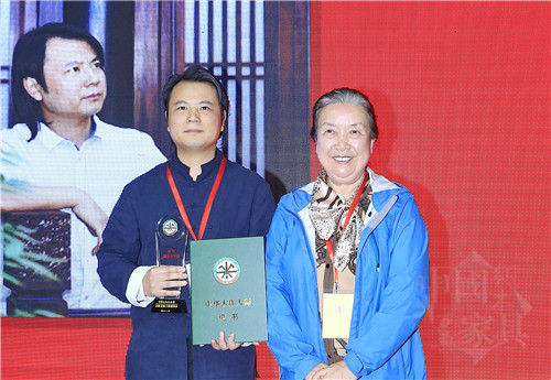 01中華兒童藝術促進會會長范崇嬿（右）為石華久（左）頒授“中華木作大師”榮譽